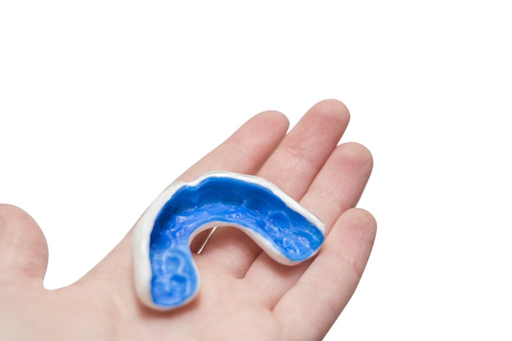 Closeup of a custom mouthguard resting on a hand dentist in Owens Cross Roads Alabama