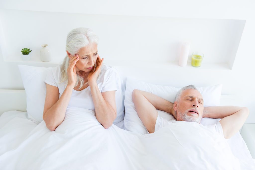 Woman holding her ears while husband is snoring oral appliance therapy sleep apnea dentist in Owen’s Cross Roads Alabama